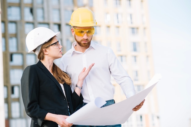 Donna che spiega i dettagli dell&#39;uomo del piano di costruzione