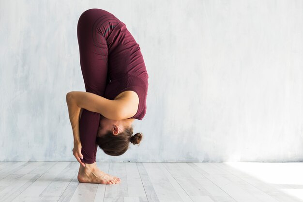 Donna che sta nella posa di yoga dell'alluce