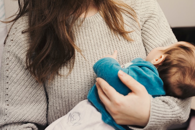 Donna che tiene bambino sveglio tra le braccia