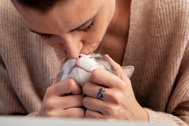 Donna che tiene il suo adorabile gattino a casa