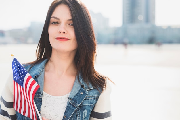 Donna che tiene la bandiera USA mentre celebra il 4 luglio fuori