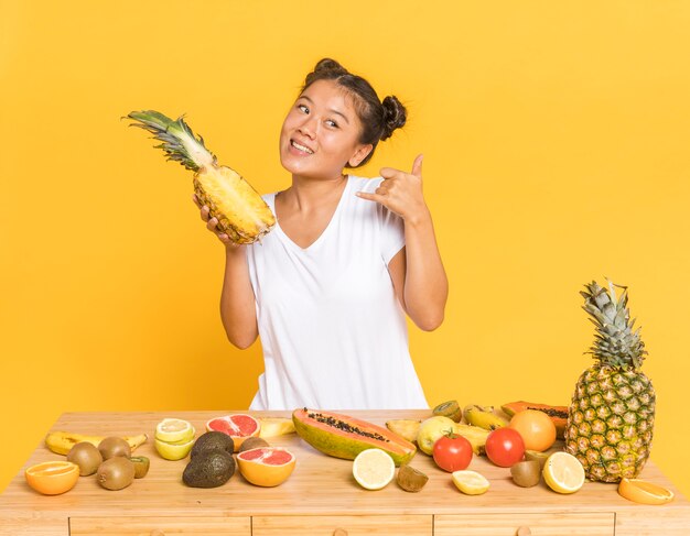 Donna che tiene un ananas e distogliere lo sguardo