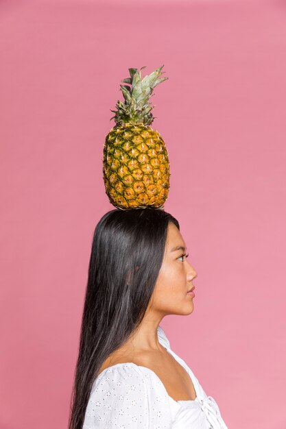 Donna che tiene un ananas sulla sua testa