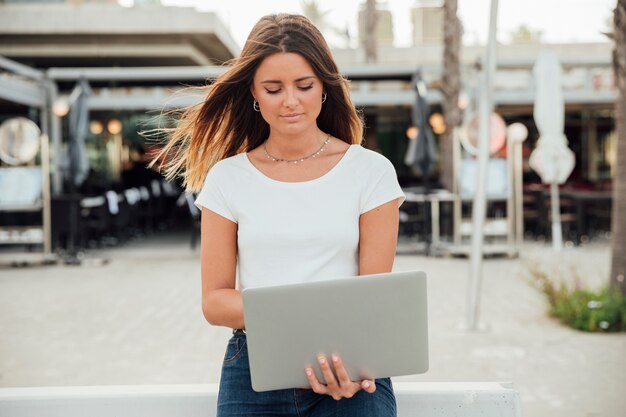 Donna che tiene un computer portatile che osserva giù