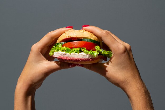 Donna che tiene un hamburger vegetariano delizioso