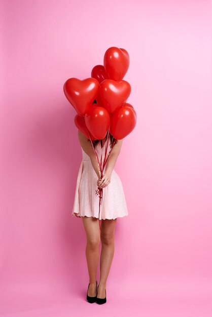 Donna che tiene un mazzo di palloncini a forma di cuore