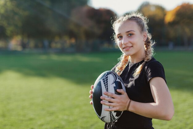 Donna che tiene un pallone da rugby con copia incolla