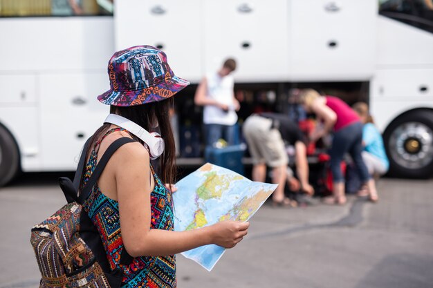 Donna che tiene una mappa presso la stazione ferroviaria Concetto di turismo