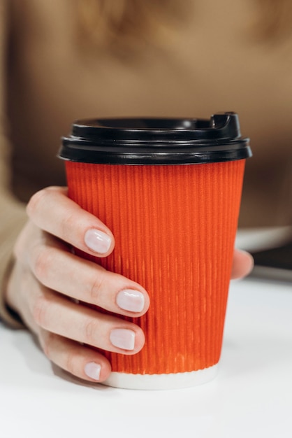 Donna che tiene una tazza di caffè al primo piano del lavoro