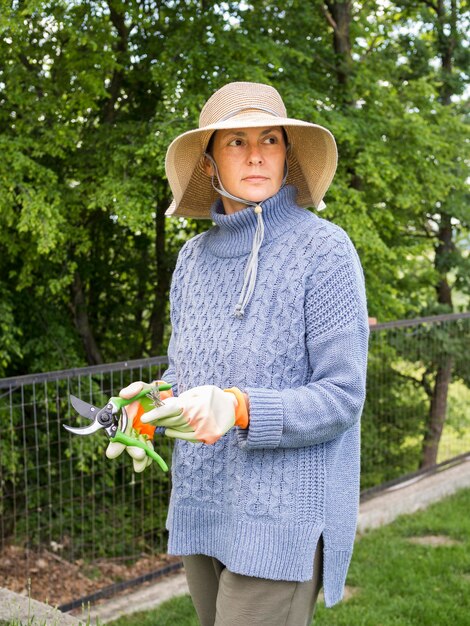 Donna che tiene uno strumento per il taglio delle foglie