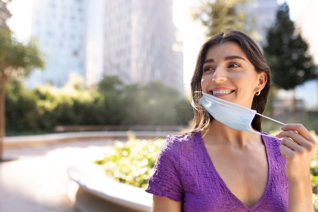 Donna che toglie la maschera dal tiro medio