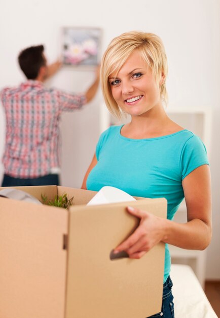 Donna che trasporta scatola con oggetti per un nuovo appartamento