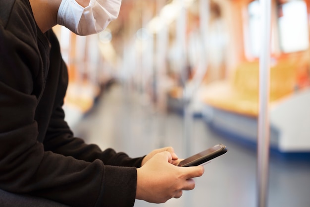 Donna che usa un telefono su un treno vuoto durante una pandemia di coronavirus