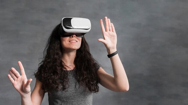 Donna che usando la vista frontale della cuffia avricolare di realtà virtuale