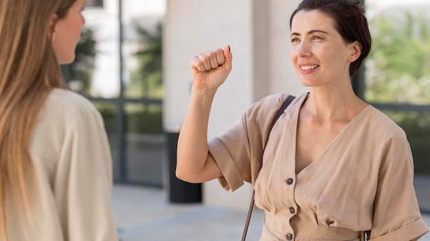 Donna che utilizza il linguaggio dei segni per conversare con la sua amica