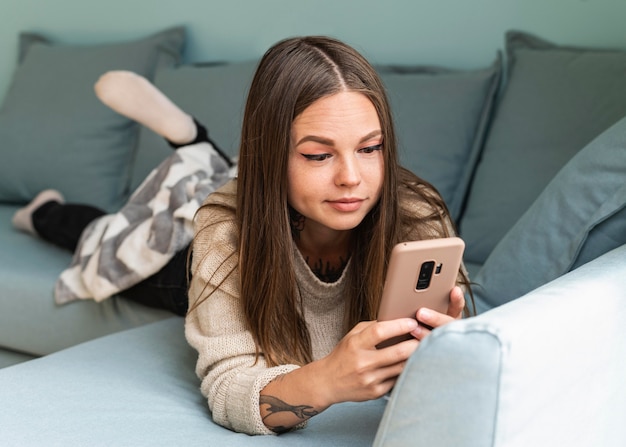 Donna che utilizza il suo smartphone a casa durante la pandemia