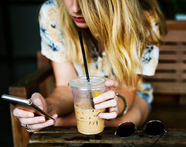 Donna che utilizza il telefono cellulare e rilassarsi al caffè