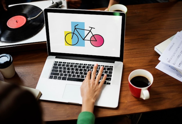 Donna che utilizza laptop Wprking con l'icona della bici sullo schermo