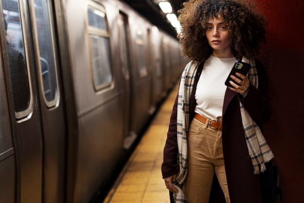 Donna che utilizza smartphone mentre viaggia con la metropolitana in città