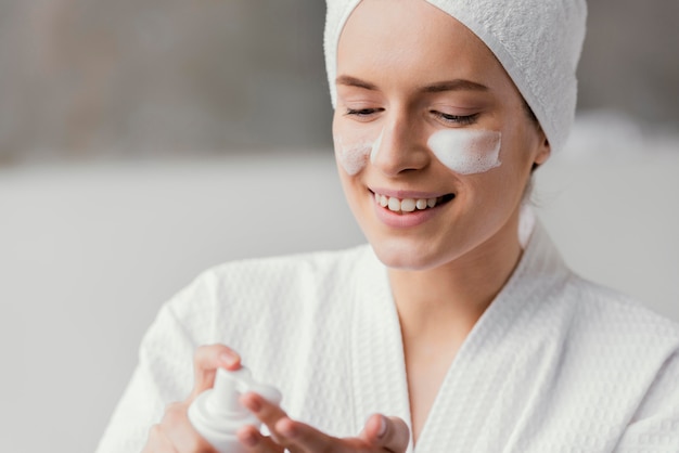 Donna che utilizza una crema per il viso bianca