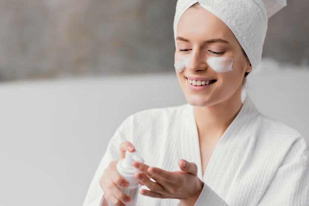 Donna che utilizza una crema per il viso bianca