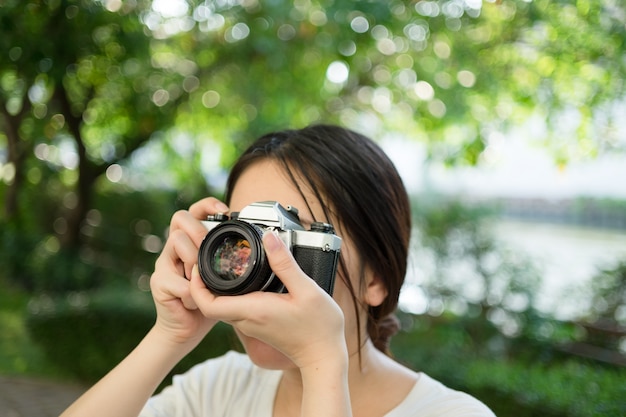 Donna che utilizza vecchia macchina fotografica d&#39;epoca