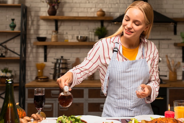 Donna che versa olio condimento sul cibo