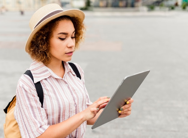 Donna che viaggia alla ricerca di indicazioni stradali su un tablet