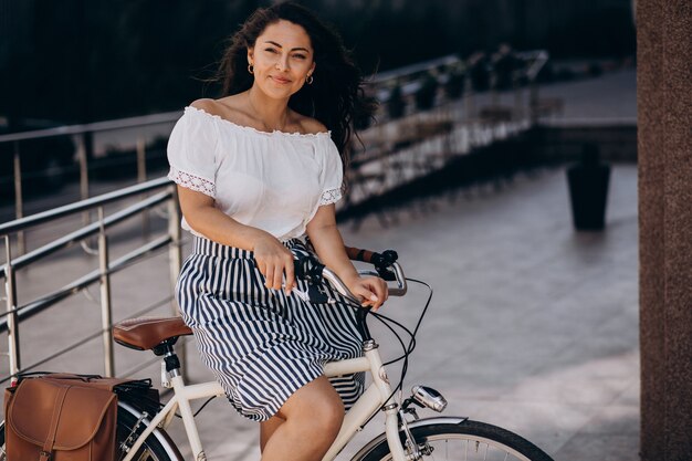 Donna che viaggia in bicicletta in città