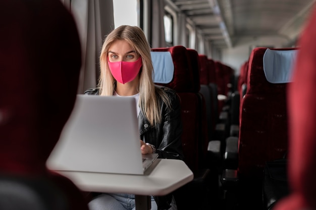 Donna che viaggia in treno e lavora al laptop