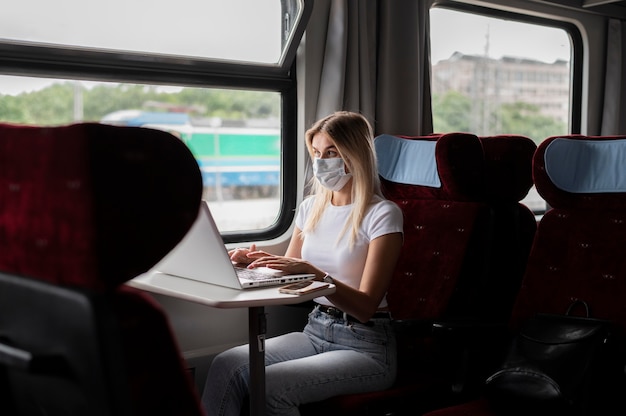 Donna che viaggia in treno e lavora al laptop