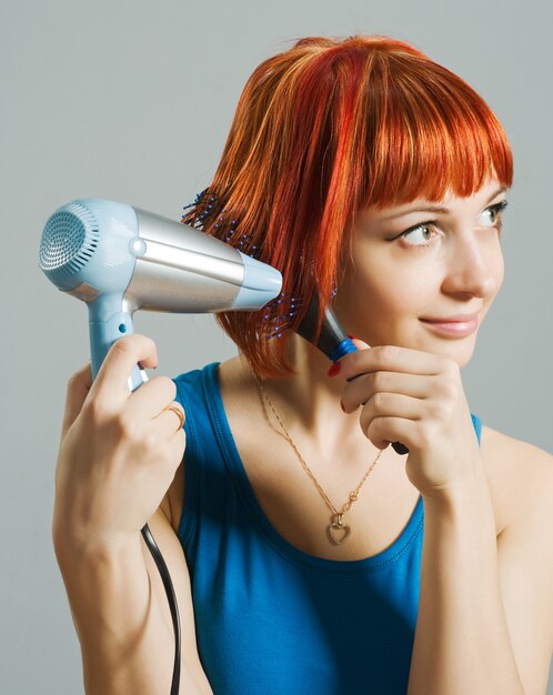 Donna con asciugacapelli e un hairbrush