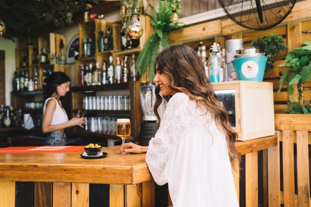 Donna con birra al bar