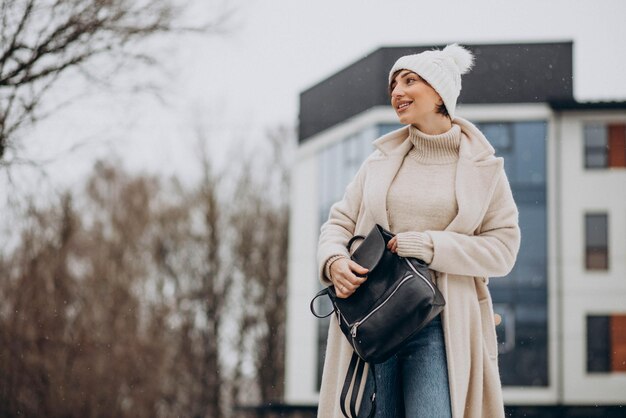 Donna con borsa che indossa un cappotto invernale che cammina per strada