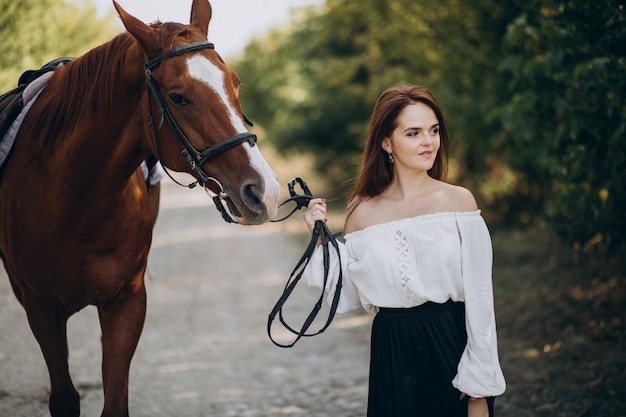 Donna con cavallo nella foresta