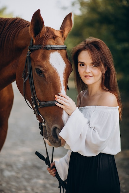 Donna con cavallo nella foresta