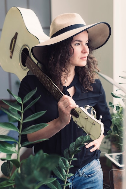 Donna con chitarra e chitarra sulla sua spalla