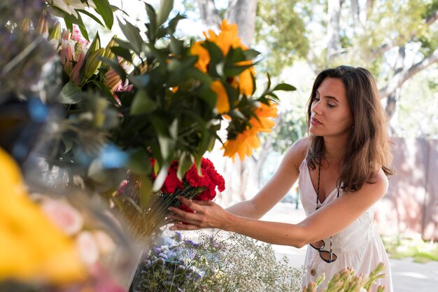 Donna con colpo medio che tiene i fiori