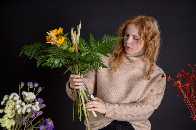 Donna con colpo medio che tiene i fiori
