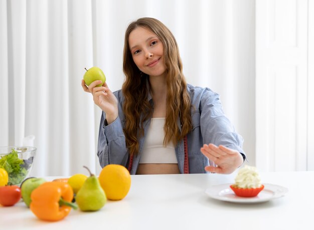 Donna con colpo medio che tiene la frutta