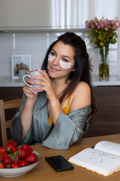 Donna con colpo medio che tiene tazza