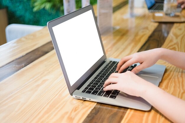 Donna con computer portatile nel negozio di caffè