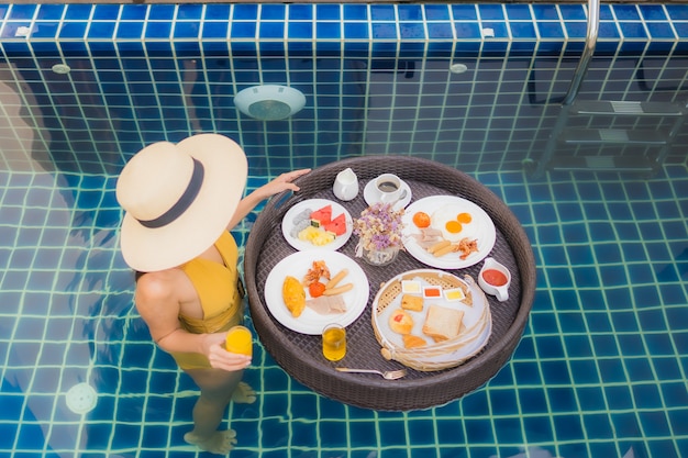 donna con con colazione galleggiante intorno alla piscina