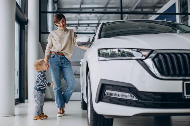 Donna con figlio bambino che sceglie un'auto in un salone di auto