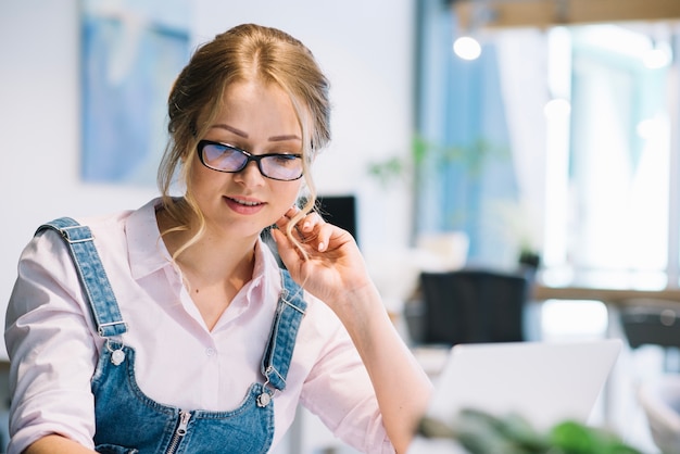 Donna con gli occhiali che lavorano in ufficio