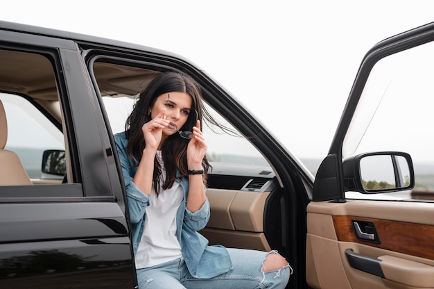 Donna con gli occhiali che viaggiano da soli in auto