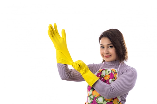Donna con grembiule colorato con guanti gialli
