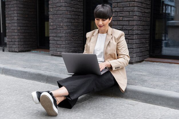 Donna con i capelli corti che controlla il suo laptop