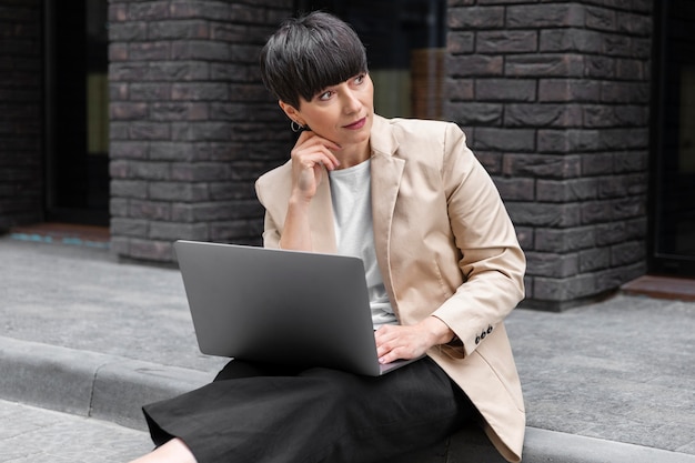 Donna con i capelli corti che controlla il suo laptop