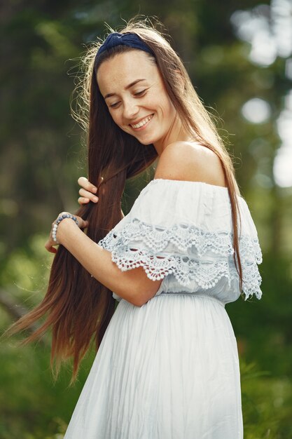 Donna con i capelli lunghi. Signora in un vestito blu. Ragazza dalla natura incontaminata.